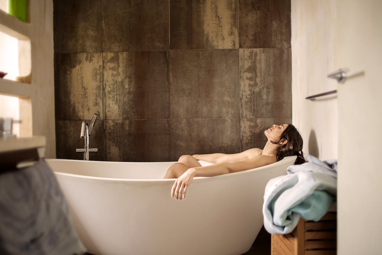 services-05 A serene moment of a woman enjoying a peaceful bath in a stylish indoor setting.